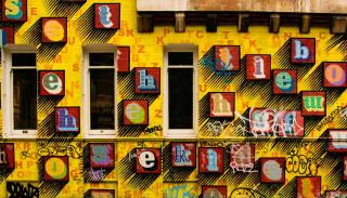Multicoloured alphabet letters set on a bright yellow wall