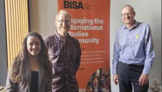 3 working group convenors posing in front of a BISA banner